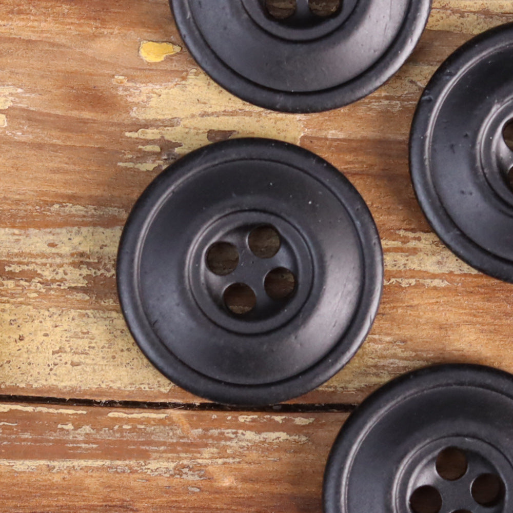 Black distressed 4-hole button with subtle speckled texture