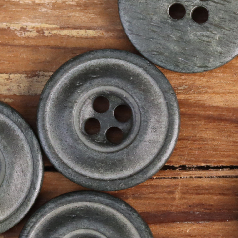Gray-green distressed 4-hole buttons, close-up on circular face