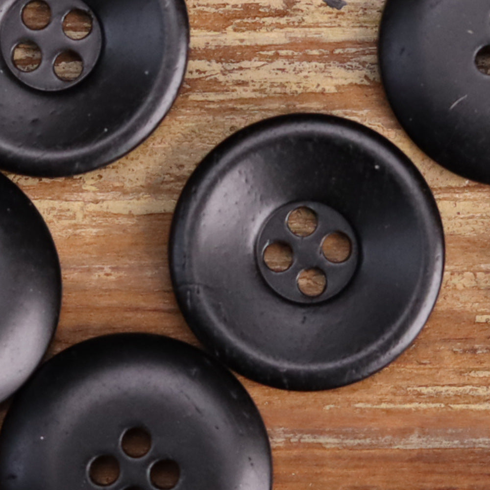 Black bowl-shaped distressed bone buttons, 4-hole fronts, grouped close-up
