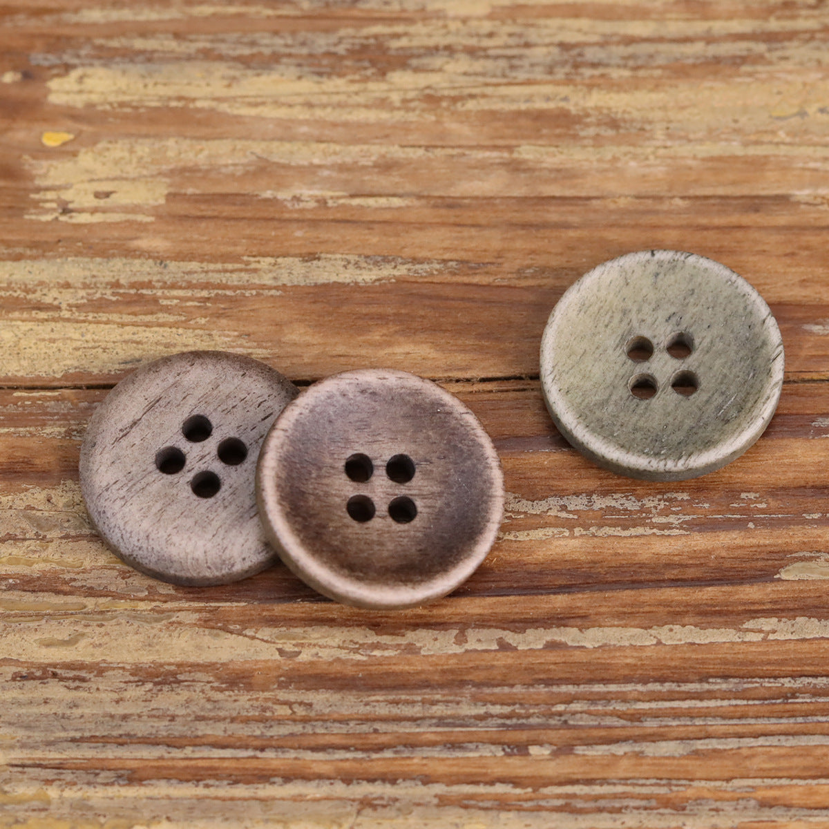 Four-hole shallow buttons in light stone and taupe tones, round textured faces