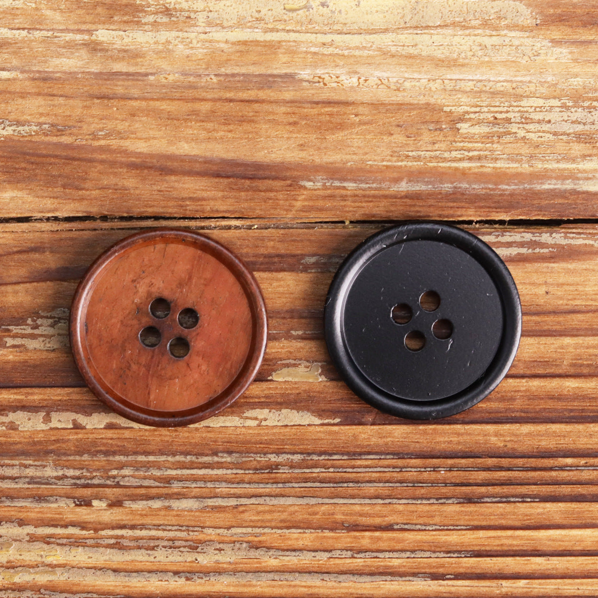 Two round buttons: black four-hole button visible with four holes on flat face.