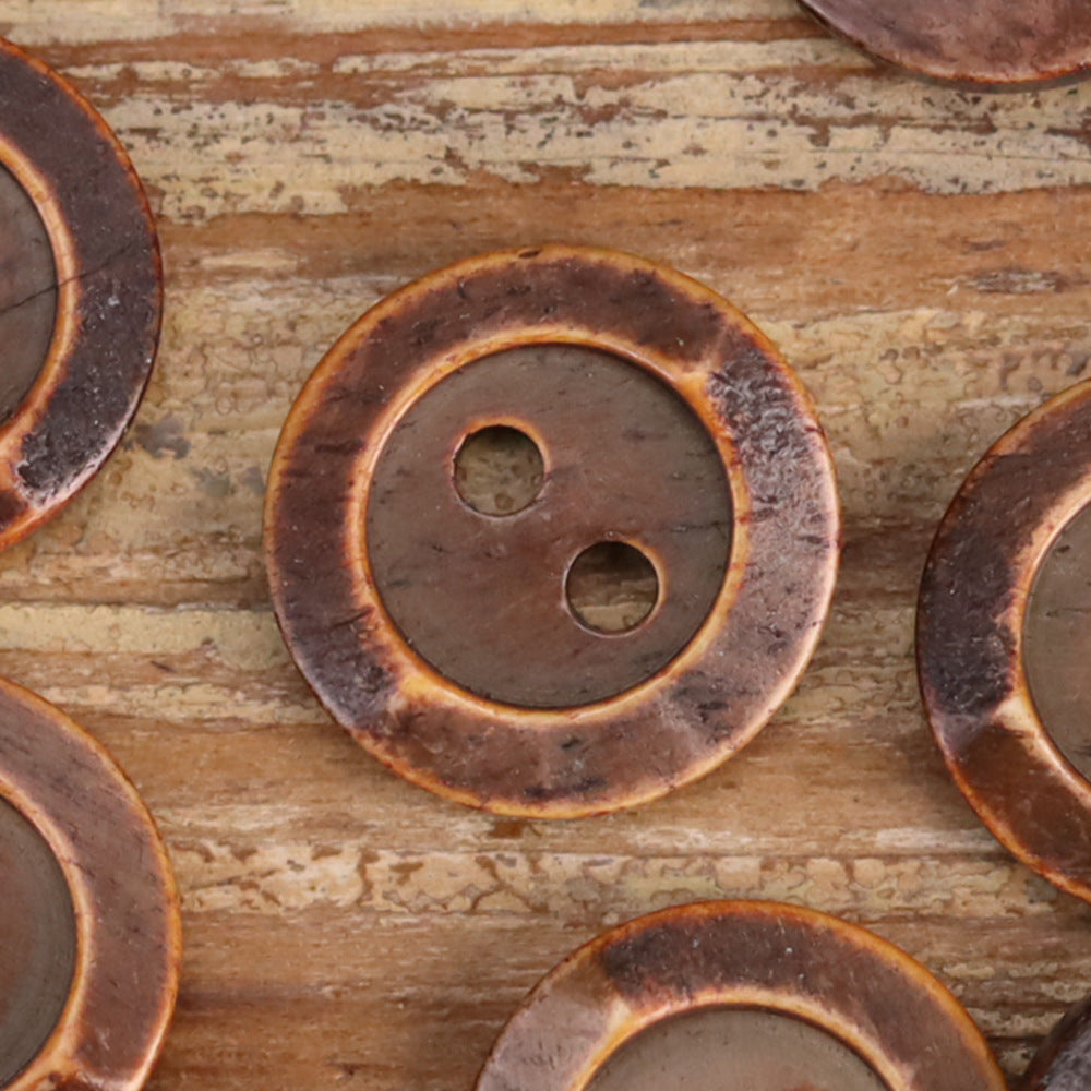 Brown round two-hole shirt buttons with bronze outer ring, close-up