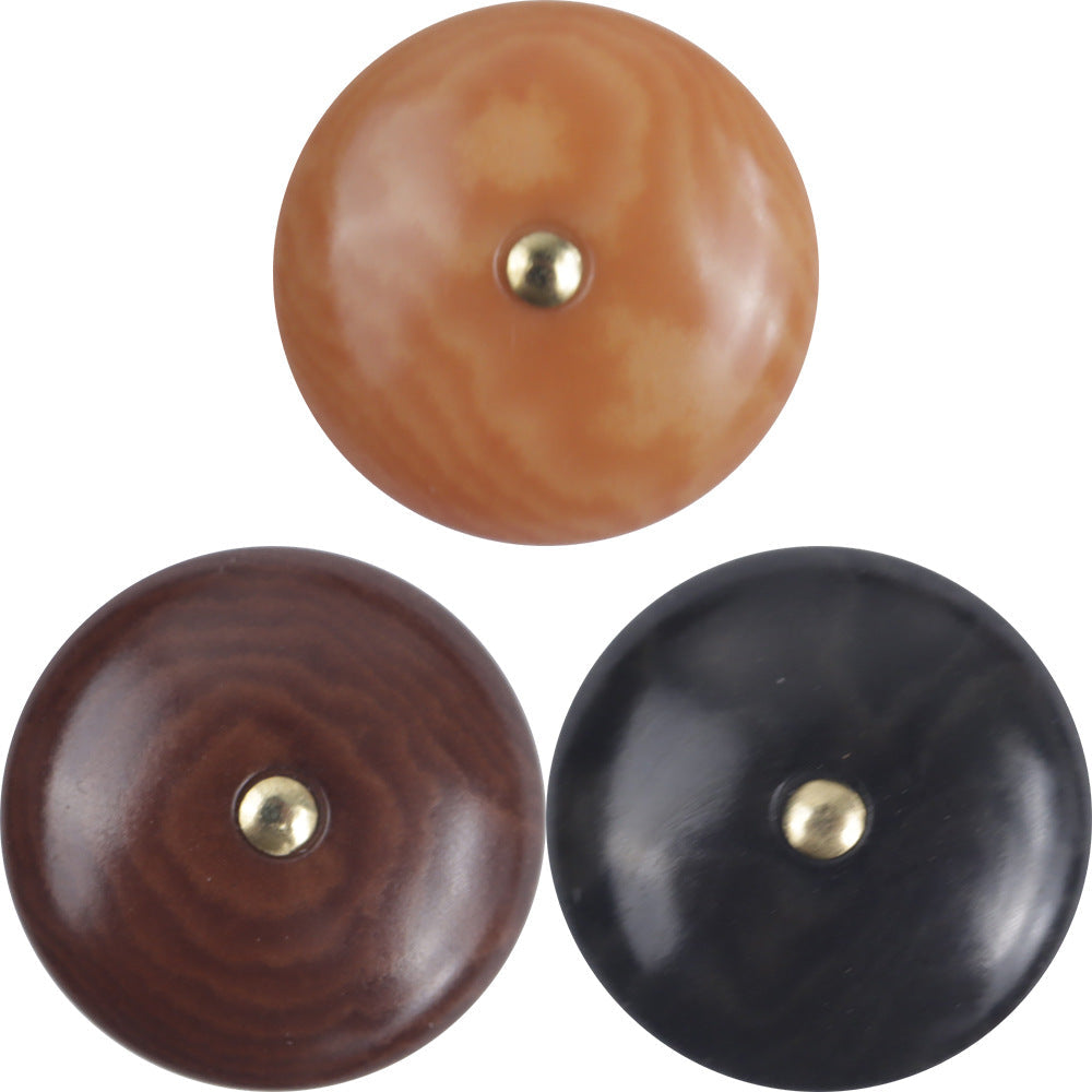Natural palm nut shank buttons close-up: orange, dark brown, and black with brass shanks.