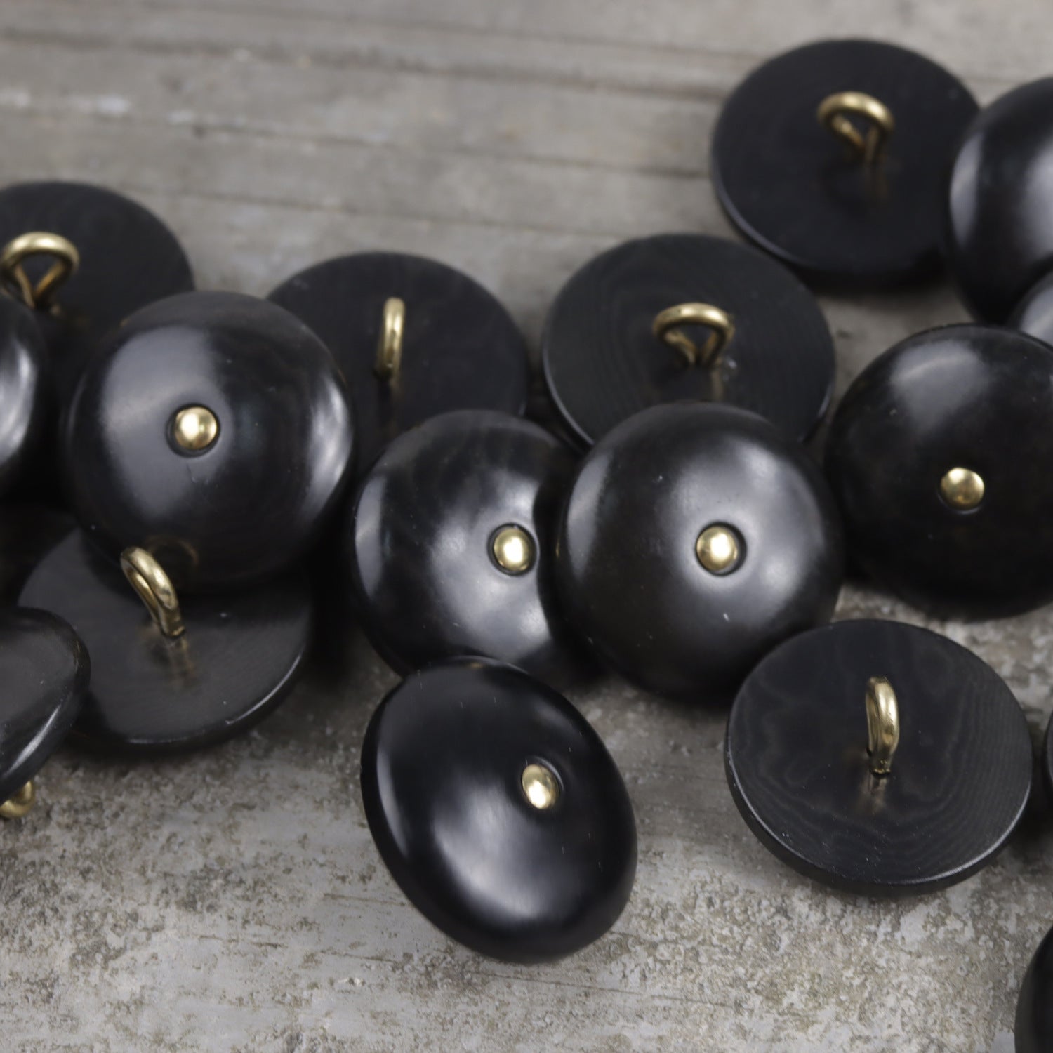 Natural palm nut shank buttons in black, round faces with brass shanks.