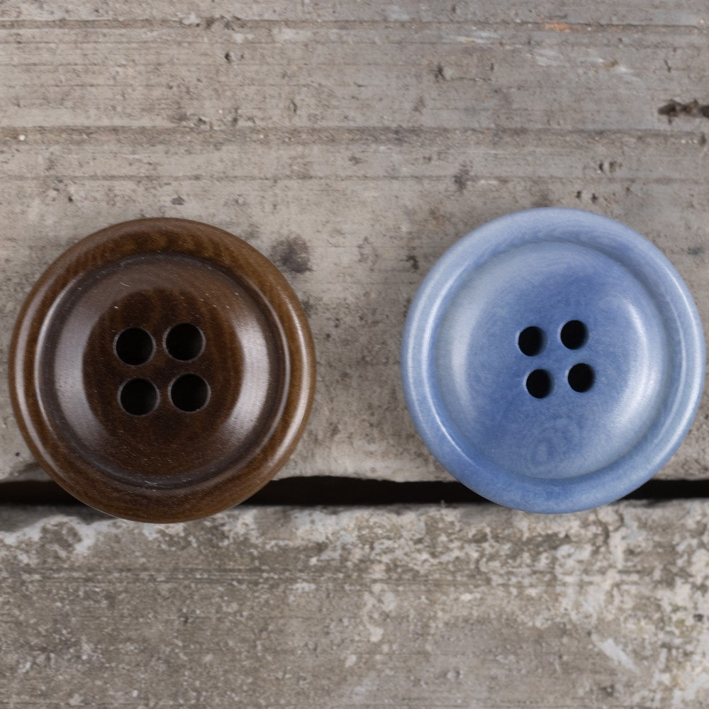 Round corozo buttons, dark brown left and sky blue right, four holes