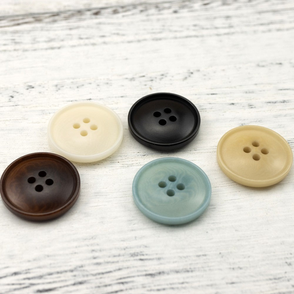 Assorted round four-hole buttons: cream, black, brown, gray-blue, and tan