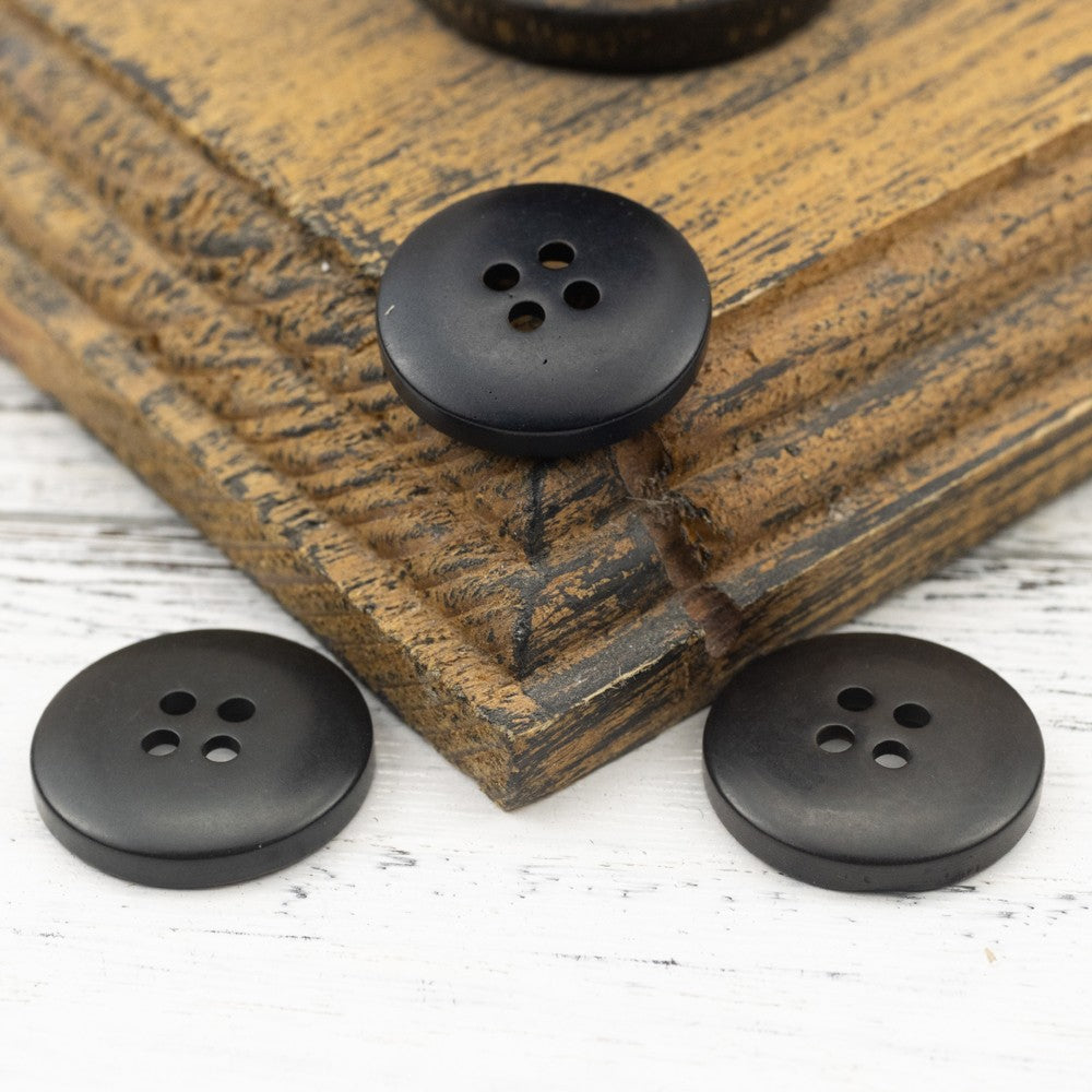 Dark nut shell button set, round face with four holes, smooth matte surface