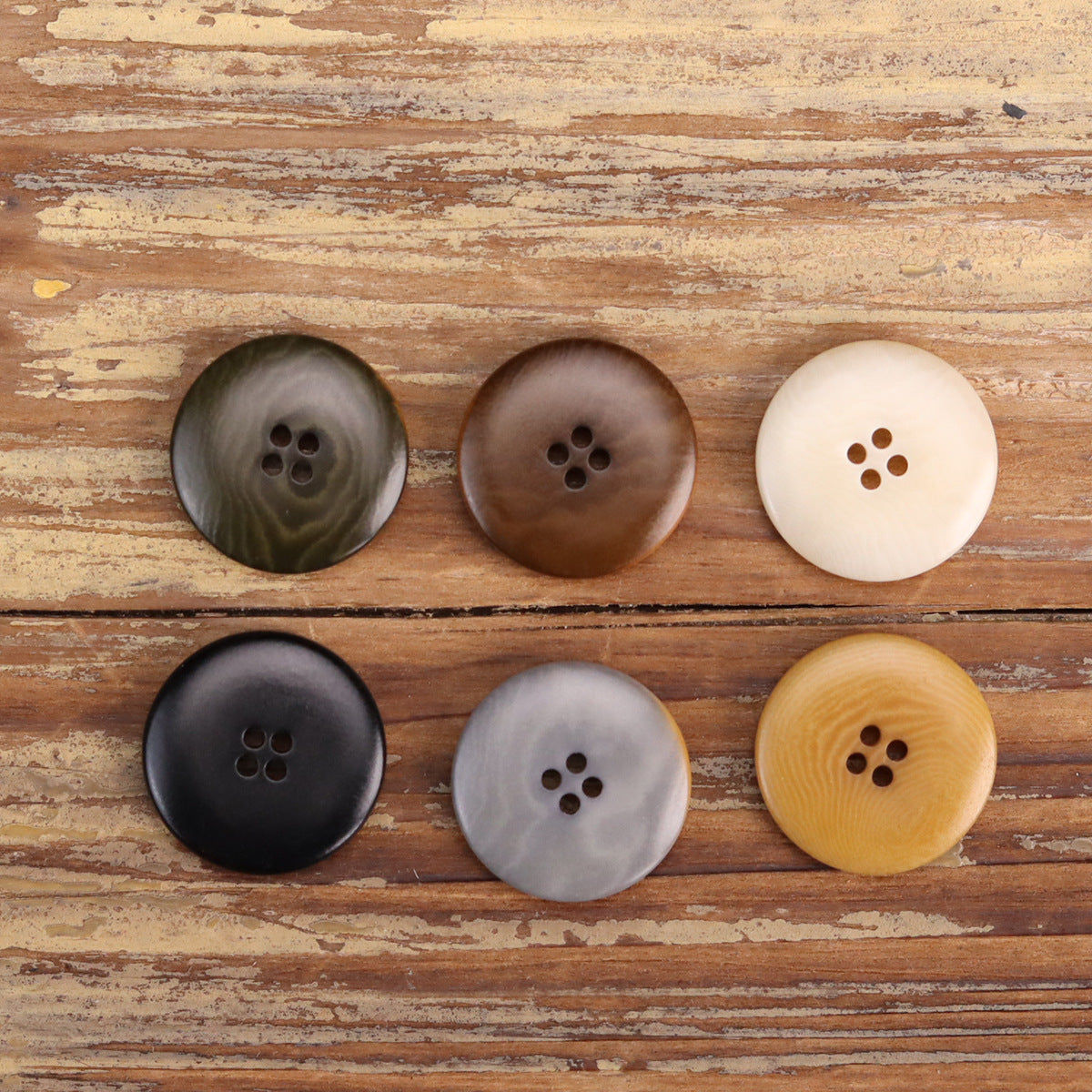 Set of nut shell buttons in dark gray, brown, and cream tones, 4-hole design