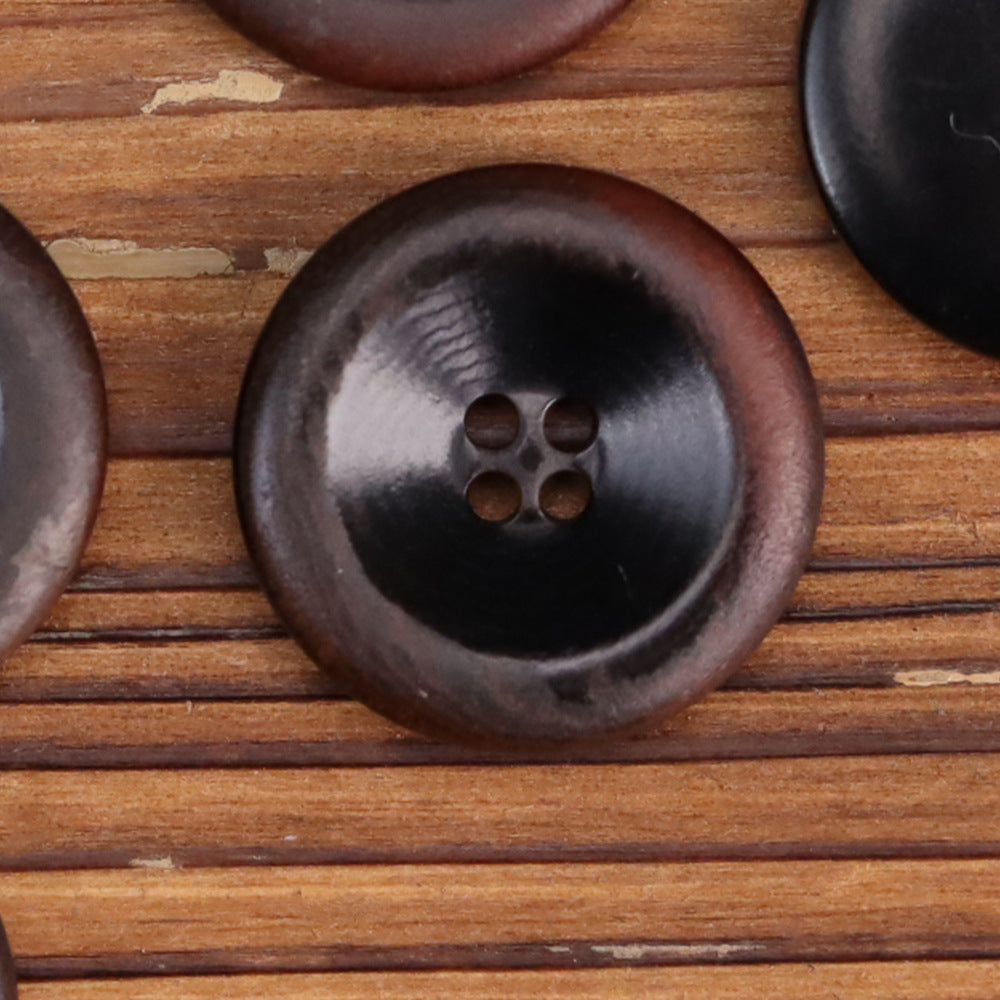 Dark brown round nut shell button with 4-hole center, 15–25mm close-up