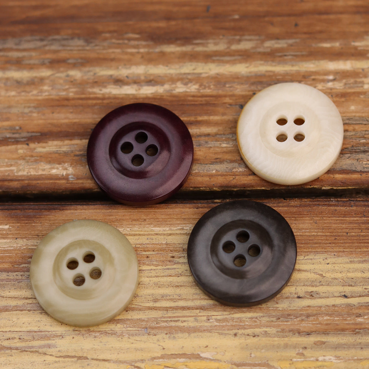 Mix of four-hole thickened nut buttons: purple, cream, dark brown, charcoal