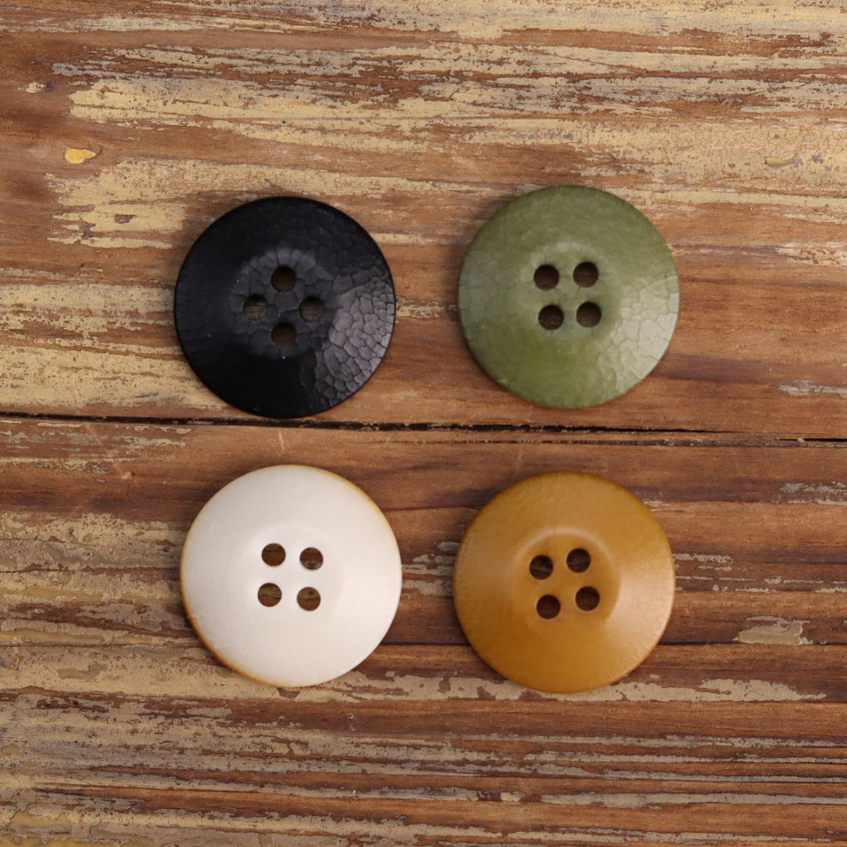 Cracked fruit buttons, mixed colors: black, green, white, and golden/tan 4-hole