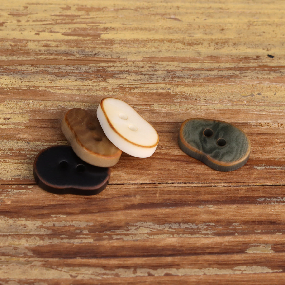 Peanut-shaped buttons in brown, cream, and gray-green, two holes each