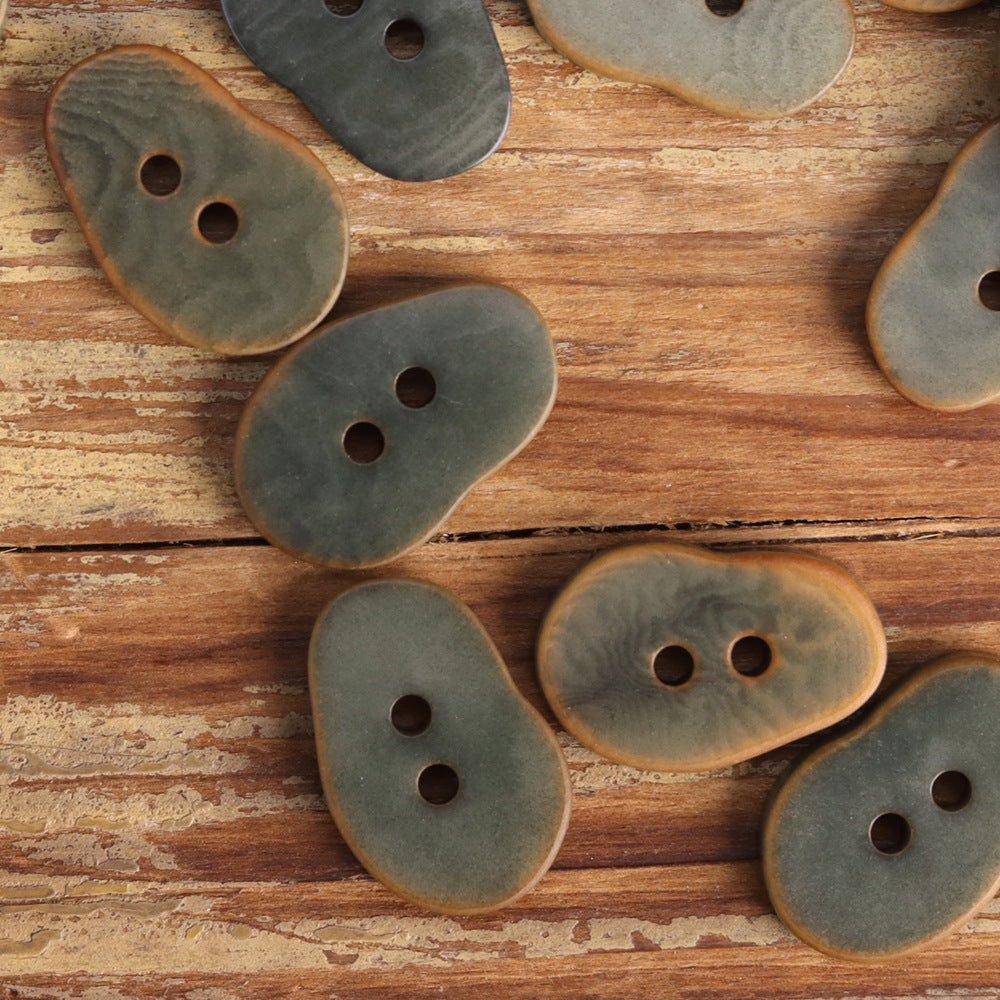 Muted gray peanut-shaped buttons with two holes each
