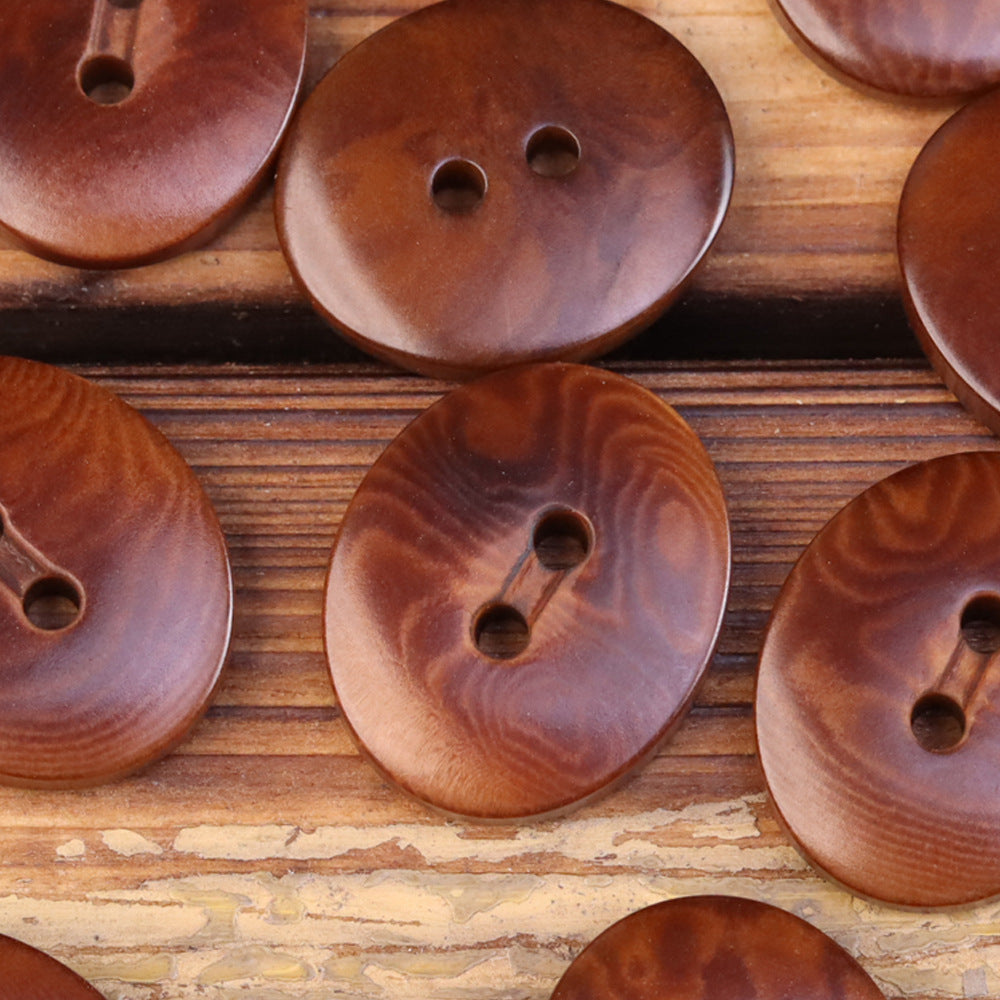 Oval 2-eye natural fruit buttons, warm brown woodgrain tone (close-up, several)