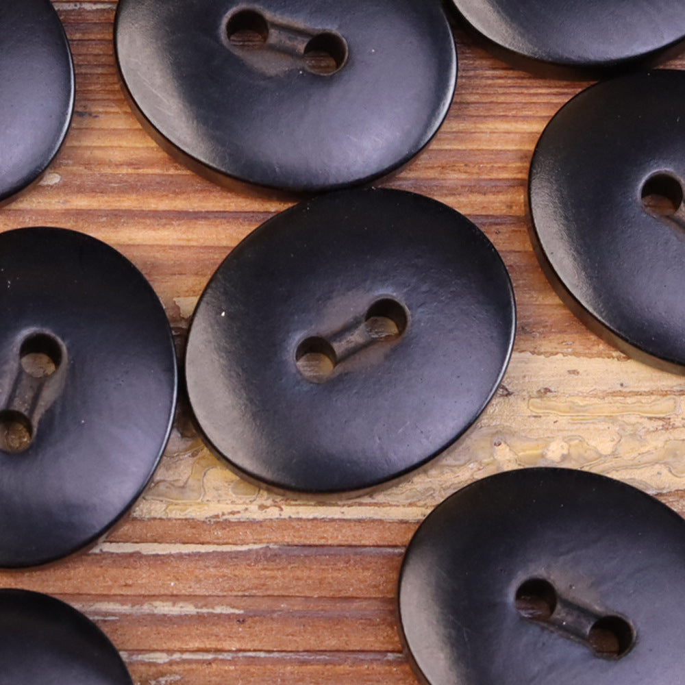 Oval 2-eye natural fruit buttons, dark navy/black tone (close-up, several)