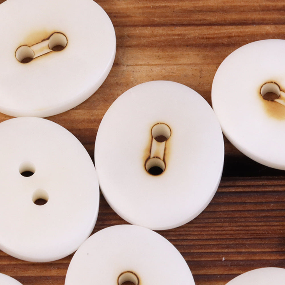 Oval 2-eye natural fruit buttons, white with loop shanks (close-up, multiple)