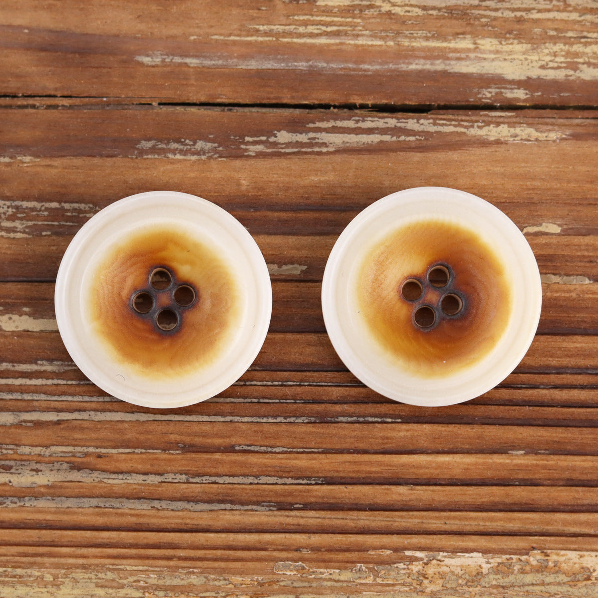 Burned white corozo buttons, two round 4-hole designs with dark centers