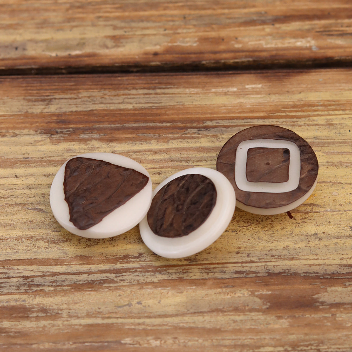 Corozo buttons with white rings and dark brown faces, various shapes