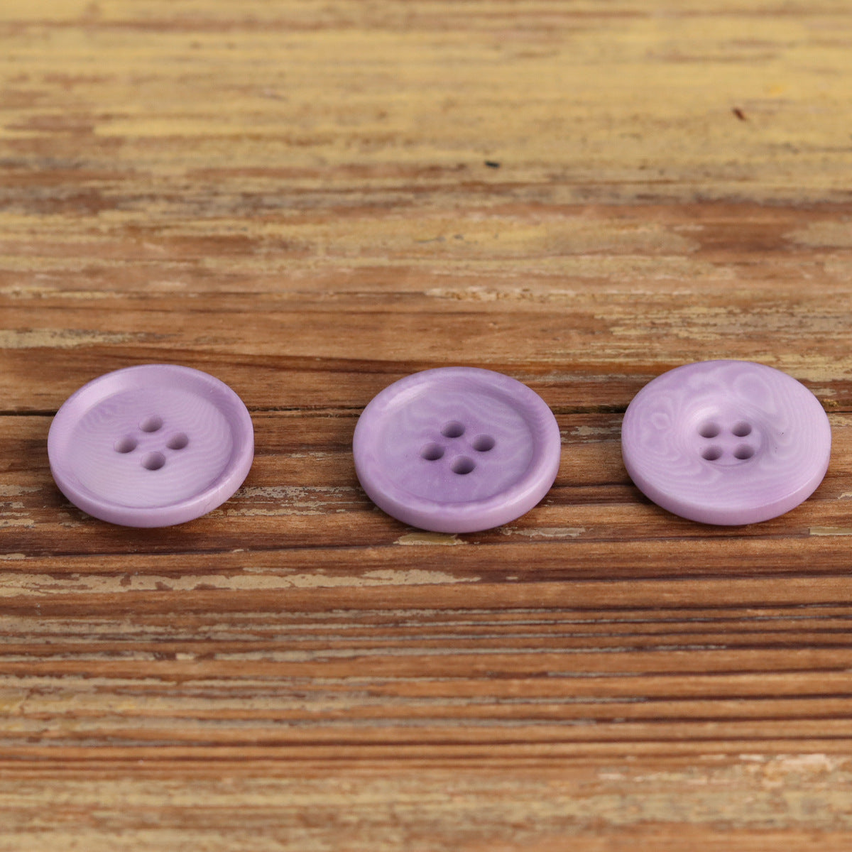 Lilac purple 4-hole corozo buttons, three round fronts in a row