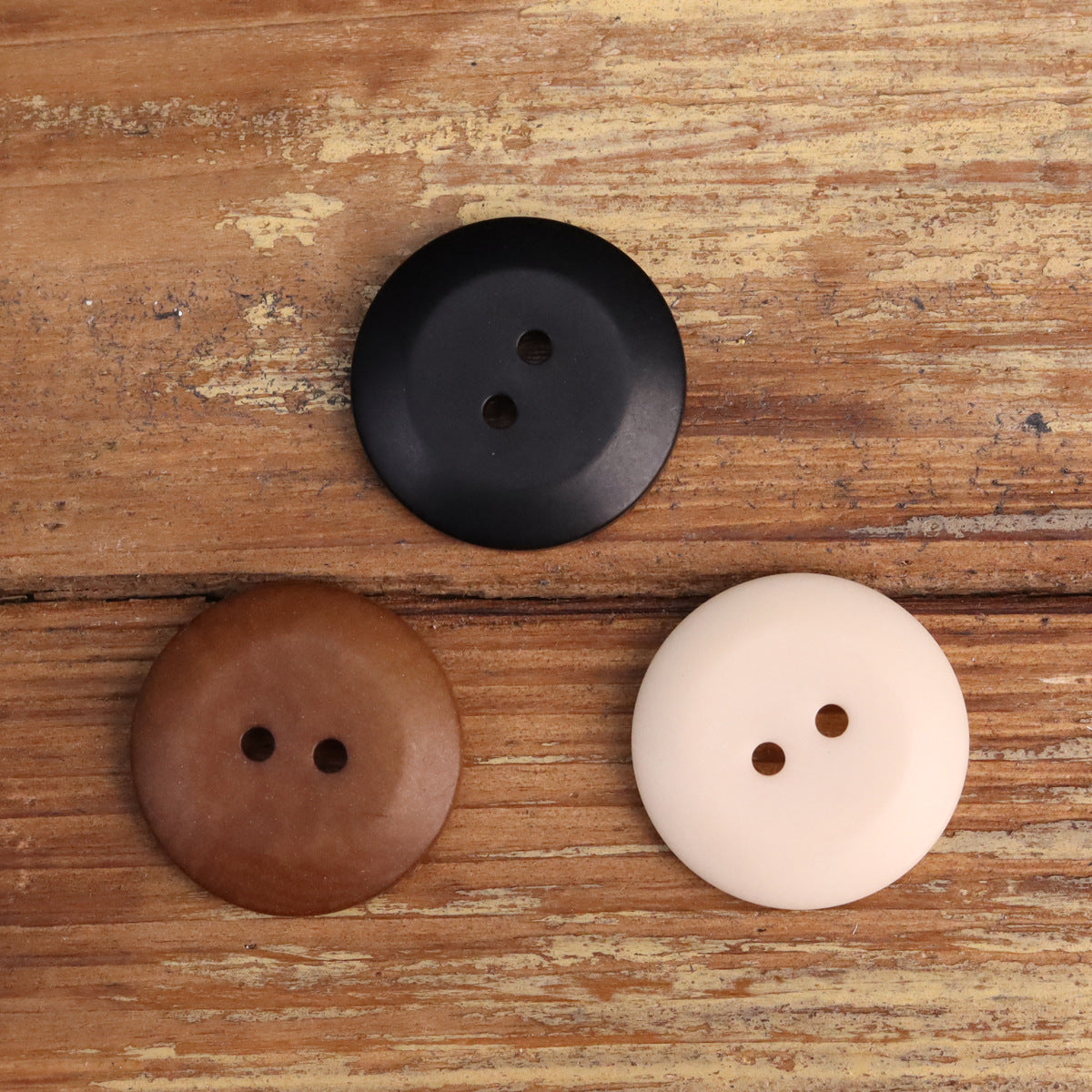 Two-hole corozo buttons: black, dark brown, and beige, round bowl-shaped design