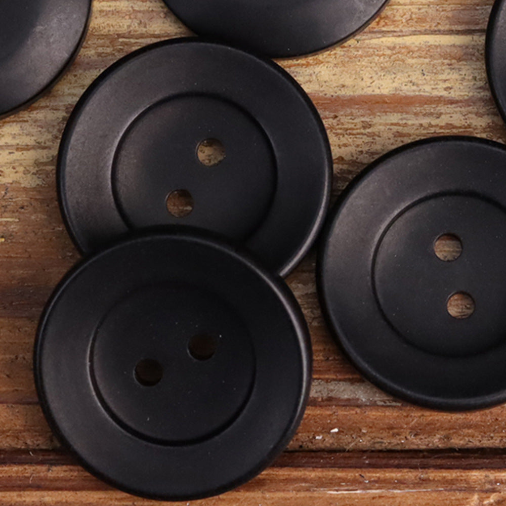 Black two-hole corozo button, bowl-shaped front with two holes