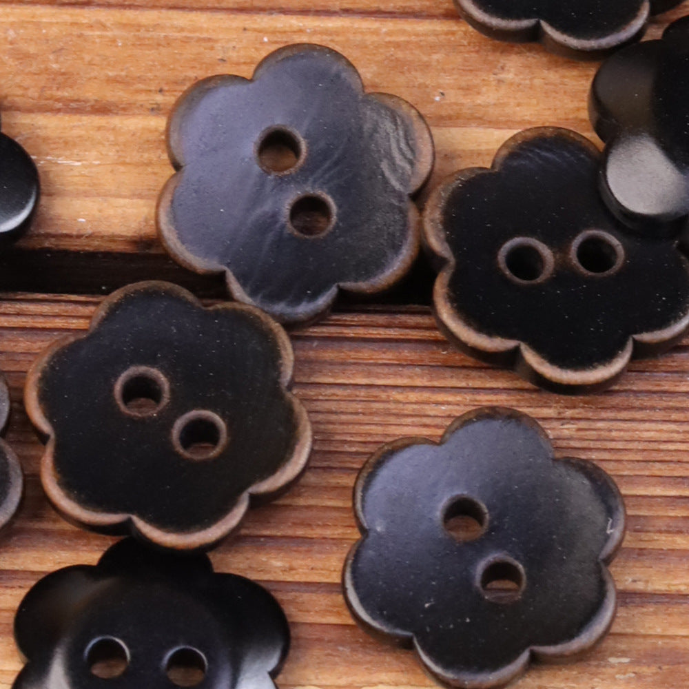 Dark flower-shaped corozo buttons, two-hole design with scalloped edges.