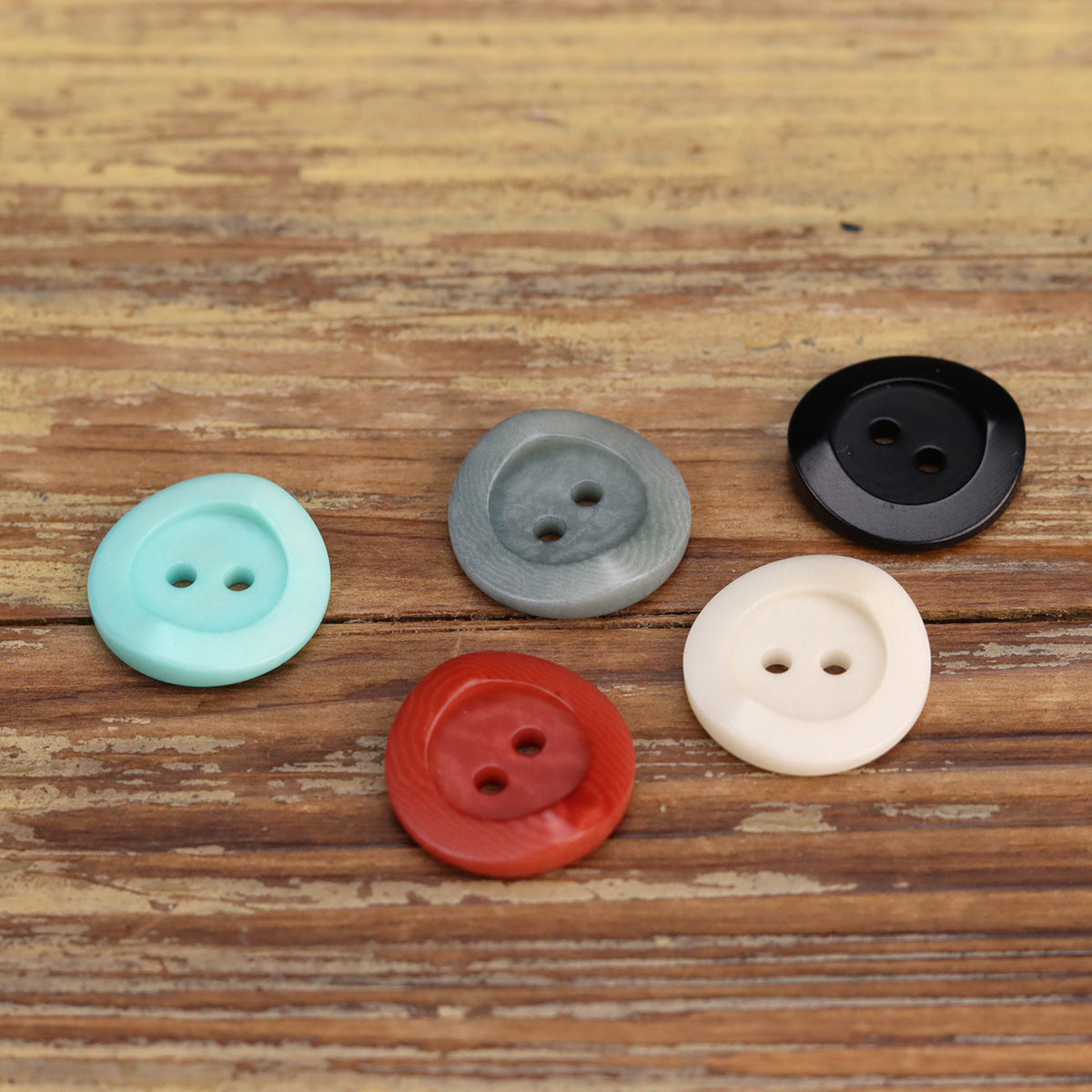 Assorted irregular corozo 2-hole buttons, including sky blue and red