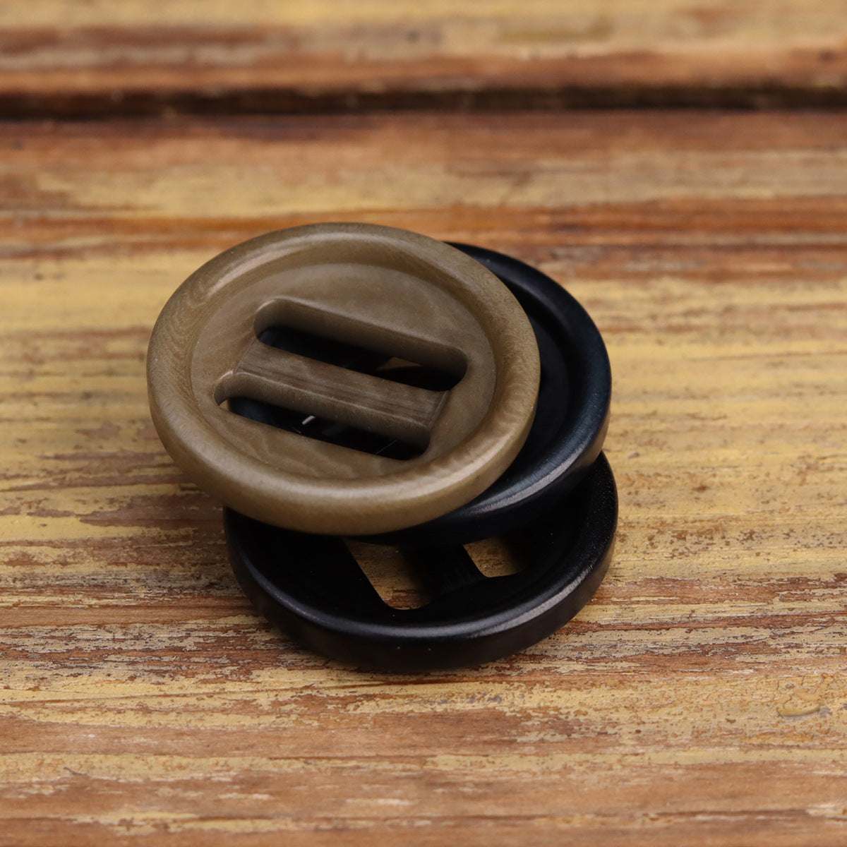 Close-up of khaki and black oblong-hole corozo-style buttons with two slots