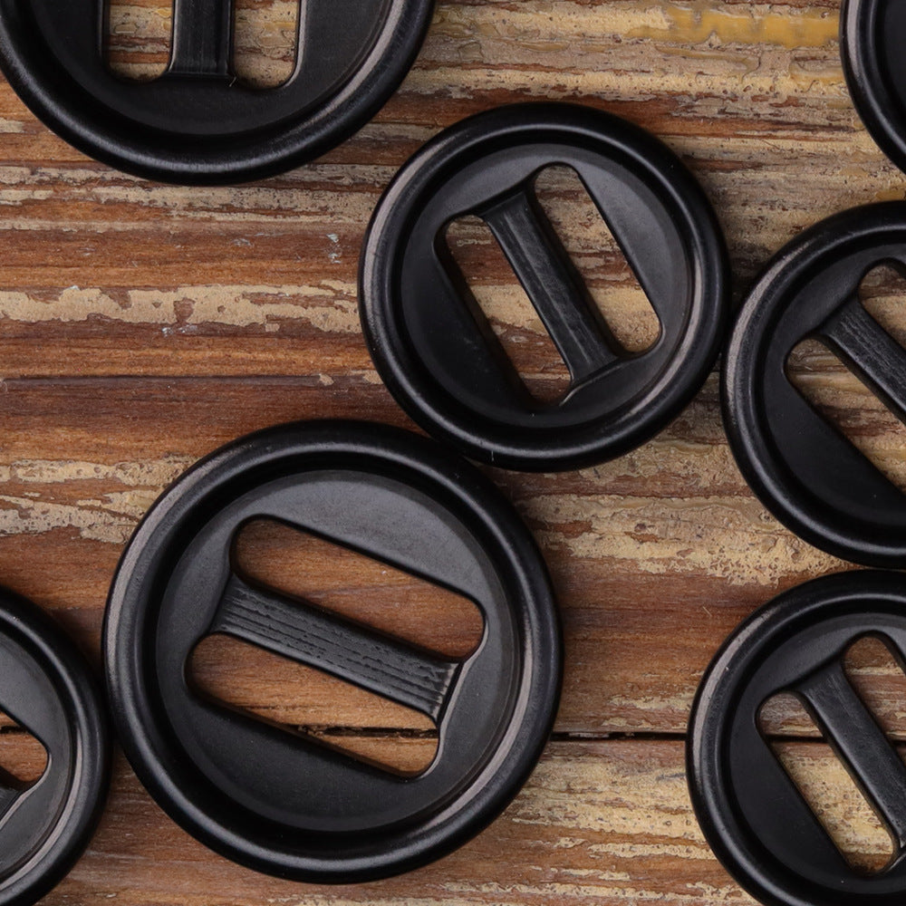 Round corozo-style oblong-hole buttons in dark gray/black; each has two oblong slots