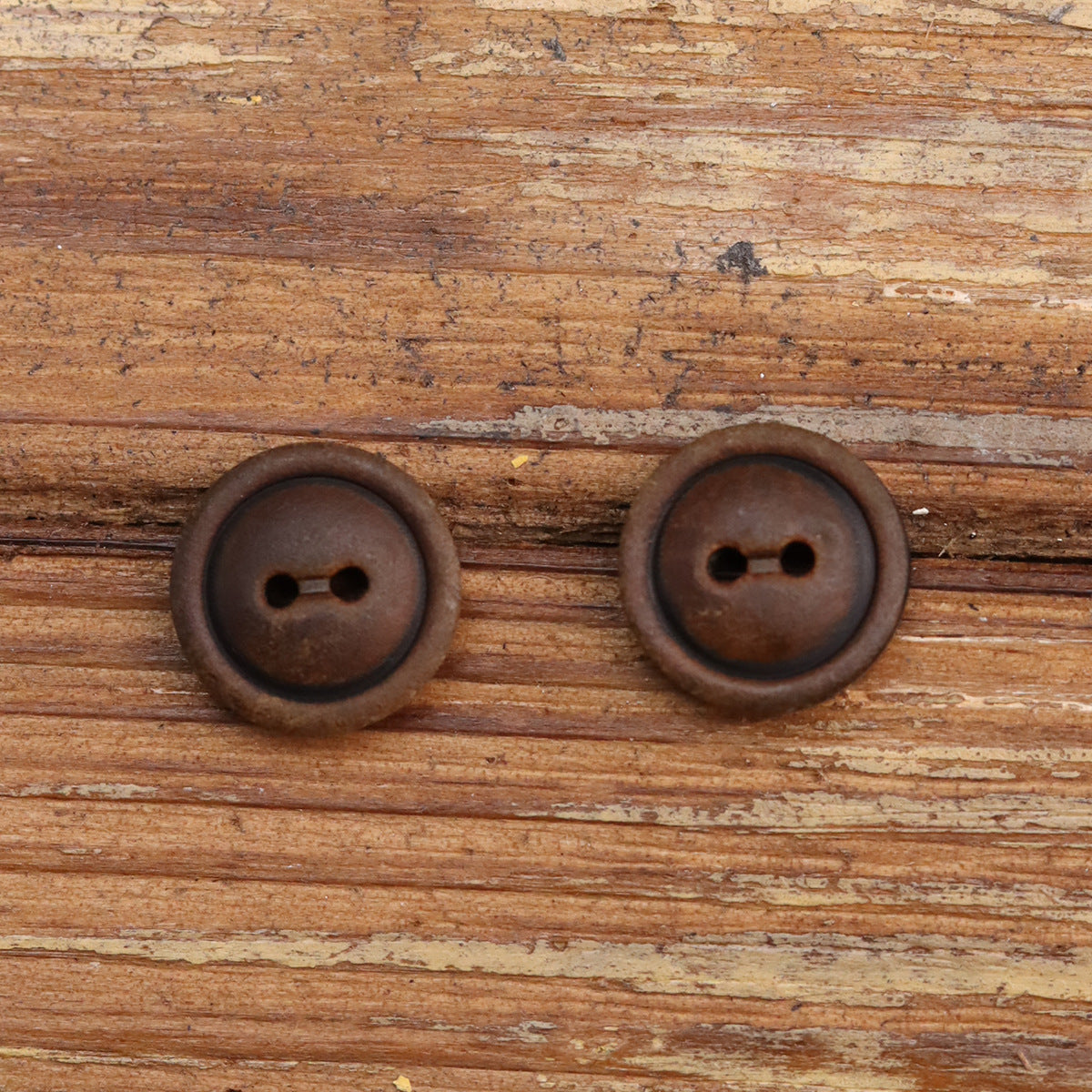 Two-hole button pair, dark brown horn-style shell with two holes, round front