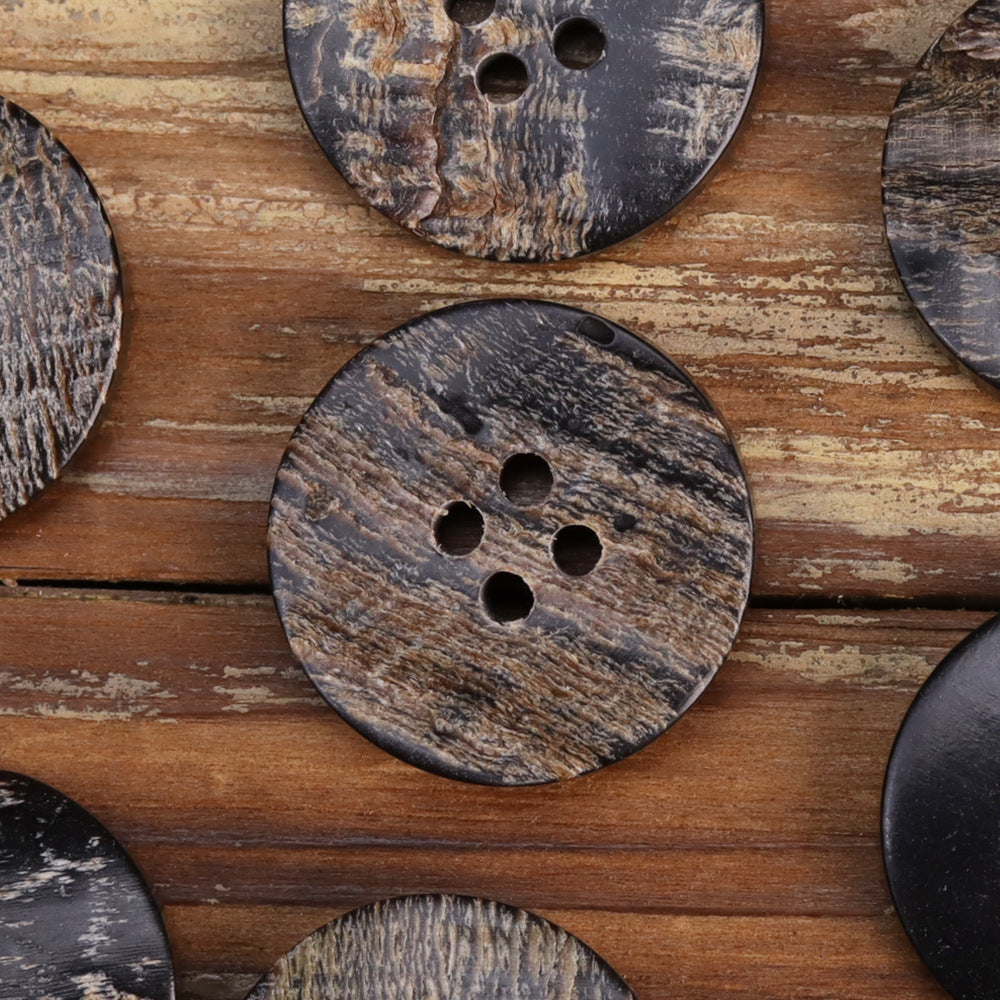 Large black irregular textured horn-look button with four holes