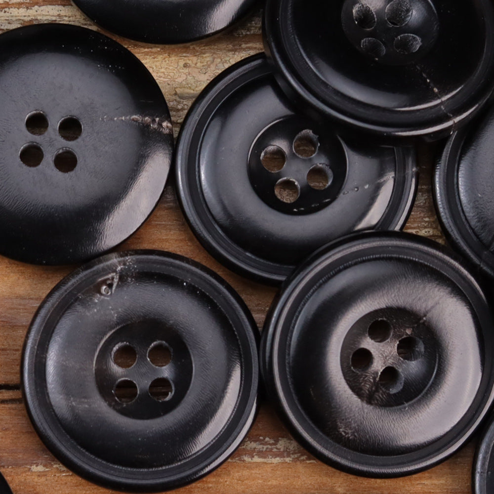 Bulk group of burnished black horn buttons, four-hole faces with glossy texture