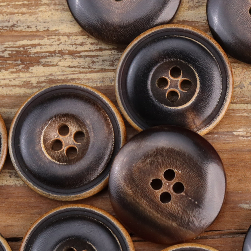 Assorted dark and coffee horn buttons with four holes and tan rims