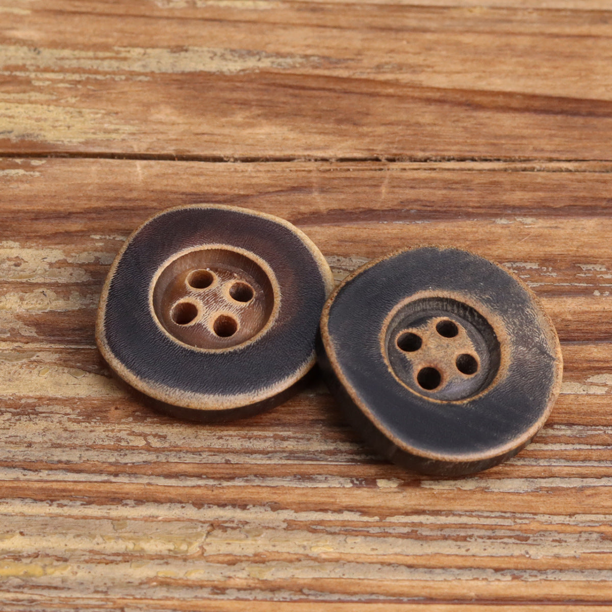 Pair irregular horn buttons with four holes, burnished rim, dark and coffee tones