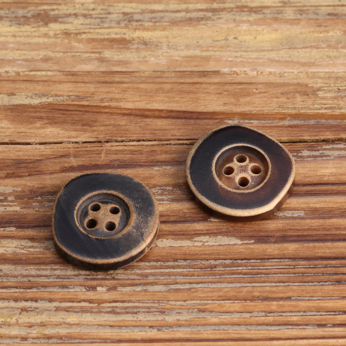 Coffee irregular horn buttons with four holes, pair, burnished edge