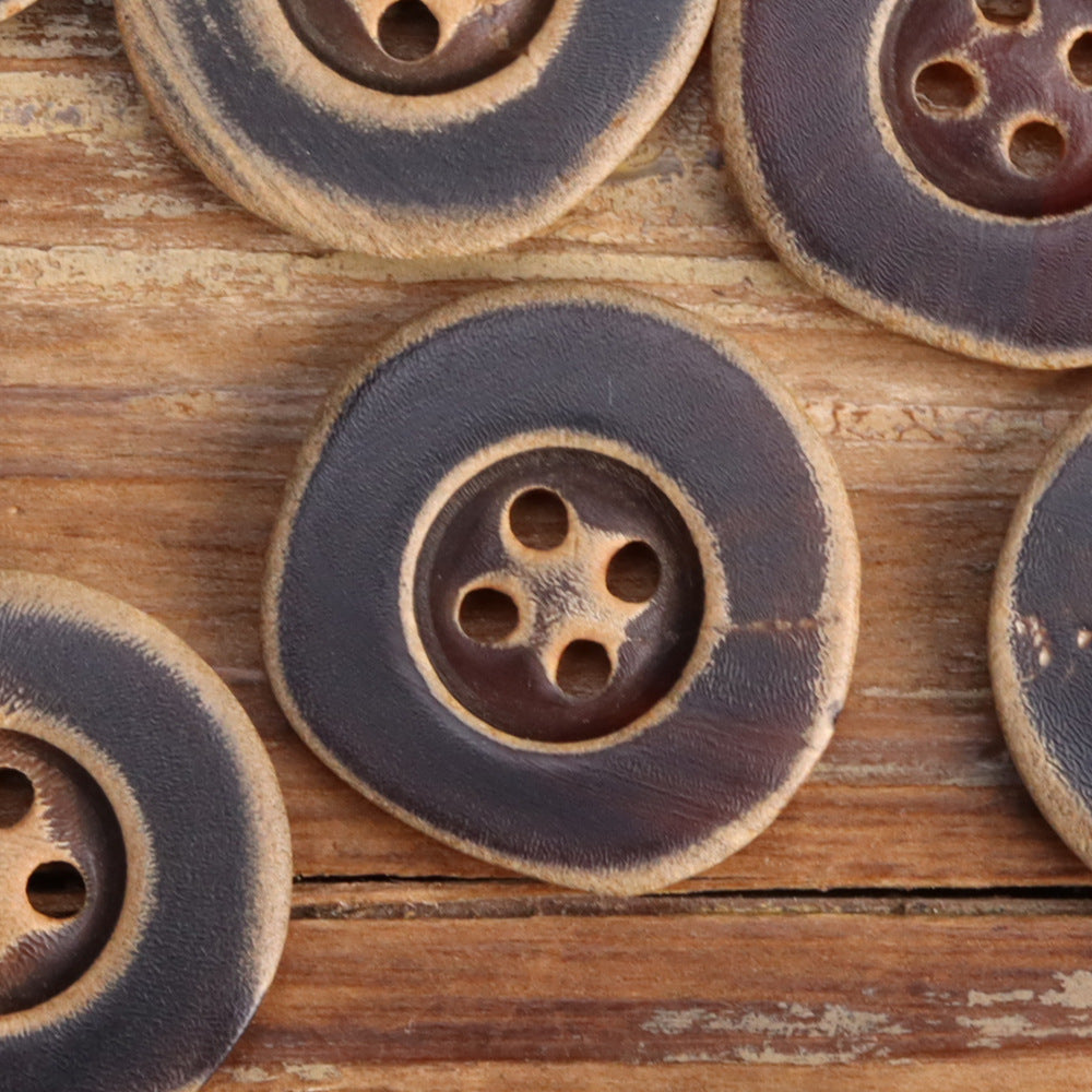 Irregular horn button with four holes, burnished dark finish, close-up