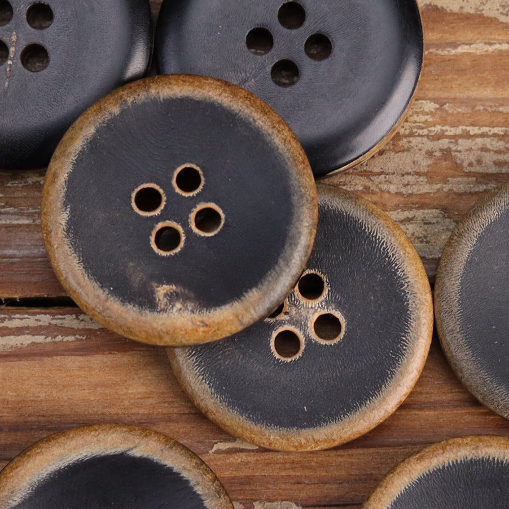 Black burnished horn buttons with four holes and warm outer ring detail