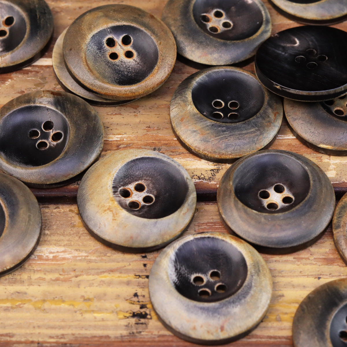 Assorted burned black horn four-hole buttons with bronze rim, pack view