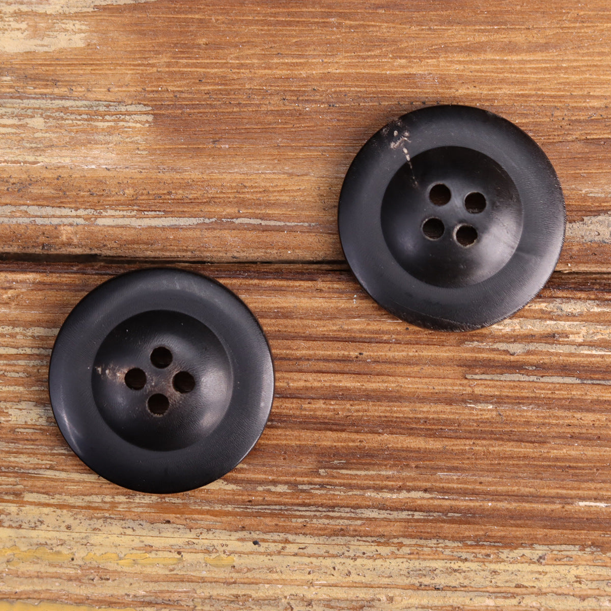 Two dark horn sailor buttons on wood, anchor motif, laser etched, 4 holes each