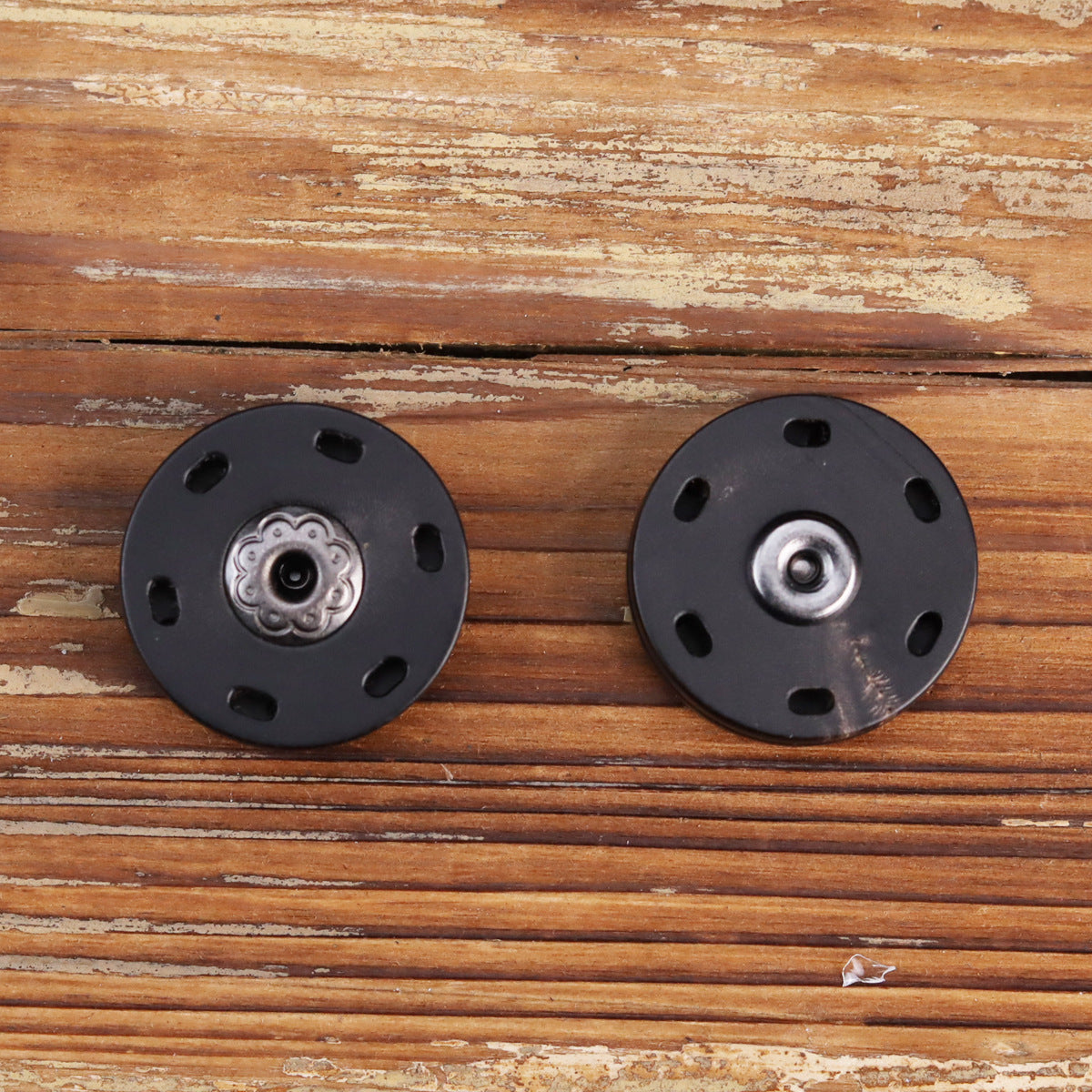 Zwei schwarze Druckknöpfe mit Zier-Rosette und Metallknopf, je 4 Befestigungslöcher