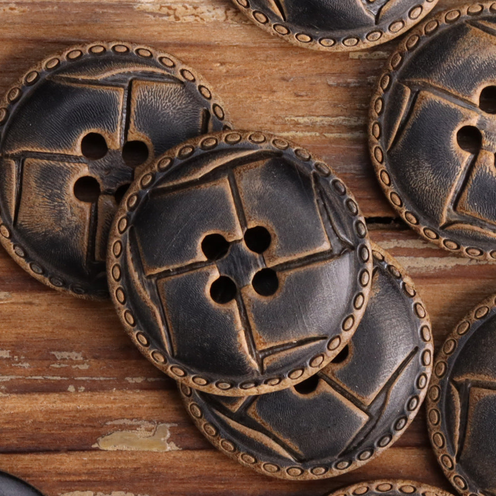 Four-hole horn-look button, Style A raised geometric panels with border.