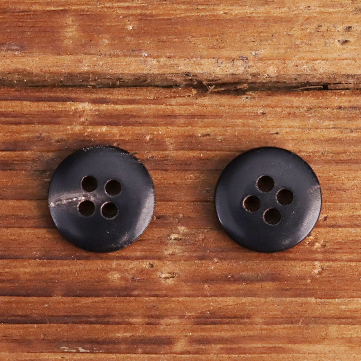 Set of dark buttons with round shape and four holes
