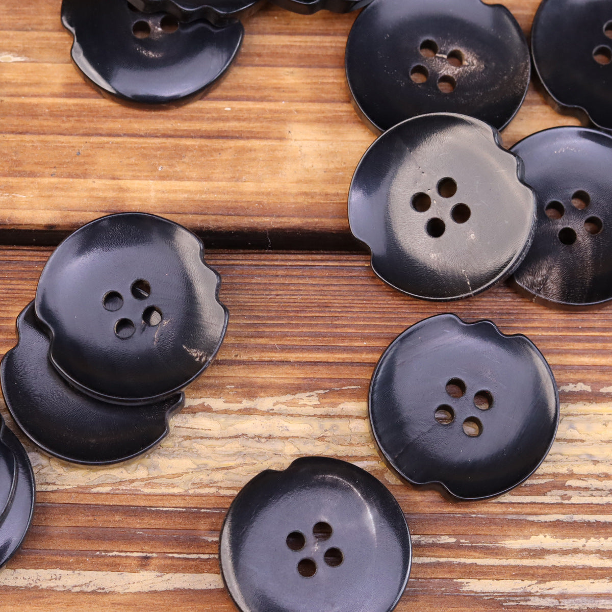 Assorted dark horn-look buttons with irregular shape and 4-hole fronts