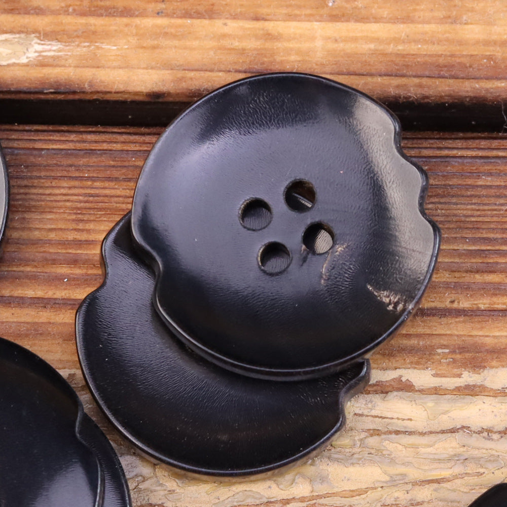 Oversized dark irregular horn-look button with 4 holes and burnished sheen