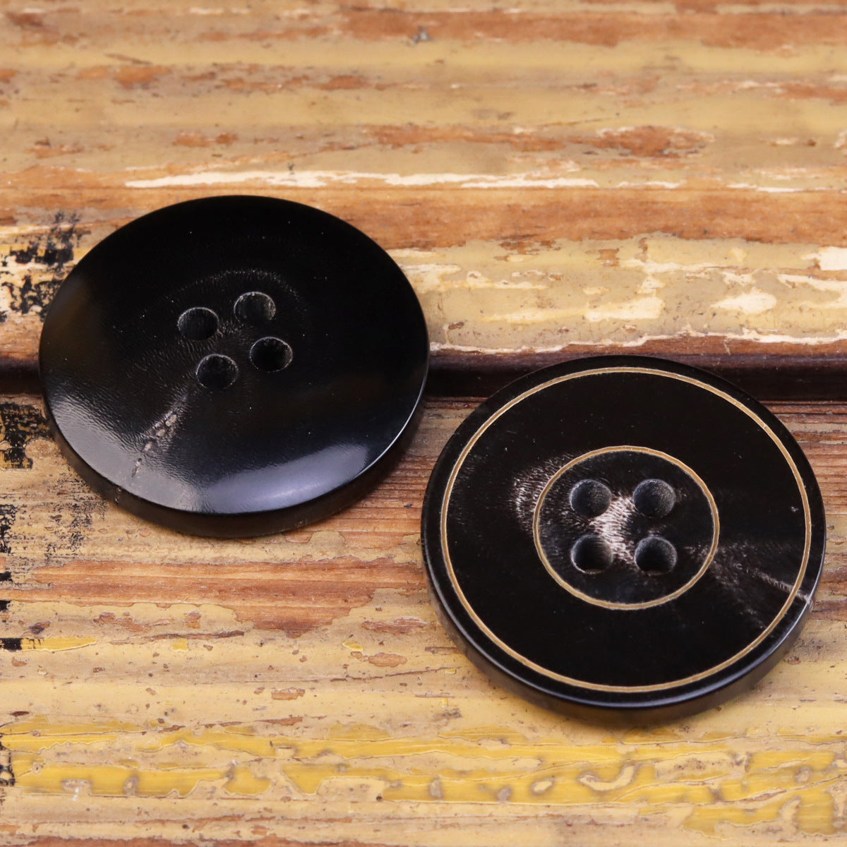 Dark jacket buttons with 4 holes and gold outline ring detail; flat grooved style (2).