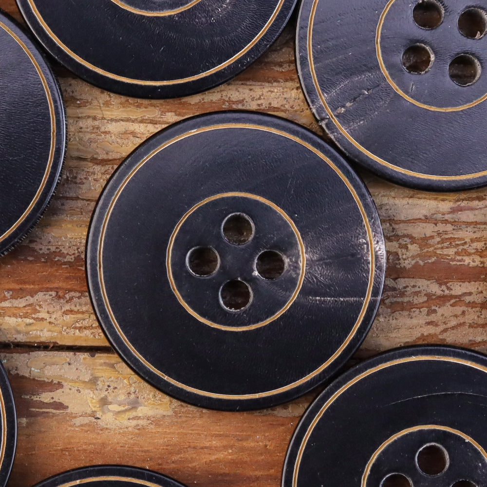 Multiple dark horn-style jacket buttons, 4 holes, yellow-outline ring detail, flat grooved.