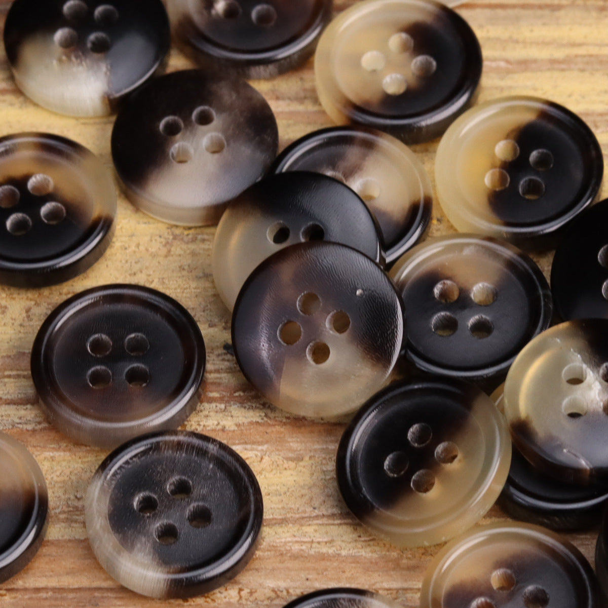 Assorted round 4-hole shirt buttons in dark, amber, and translucent horn tones