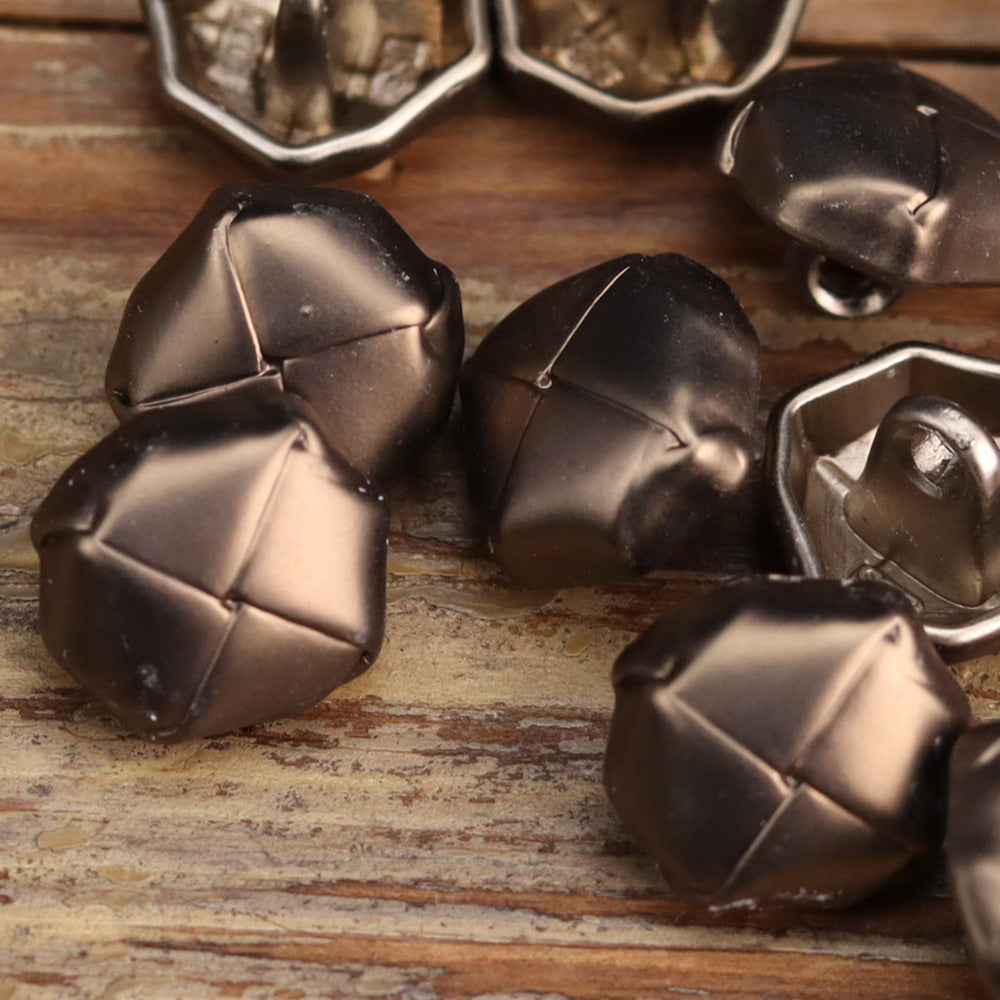 Mixed distressed metal buttons showing cross-panel detailing; dark bronze and silver tones