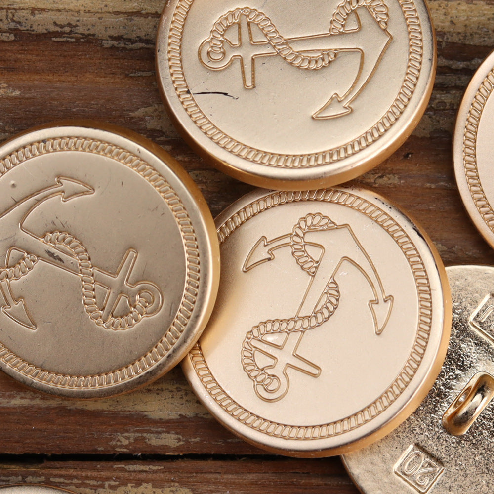 Rose gold and silver anchor buttons, close-up round fronts with engraved rope anchor