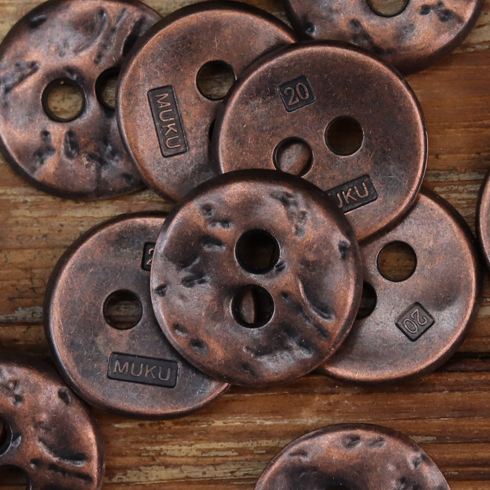 Red bronze irregular two-hole metal buttons with dark speckled texture and MUKU mark